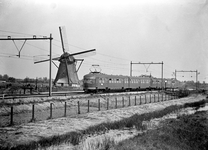 150902 Afbeelding van een electrisch treinstel mat. 1946 van de N.S. ter hoogte van Hazerswoude, met op de achtergrond ...